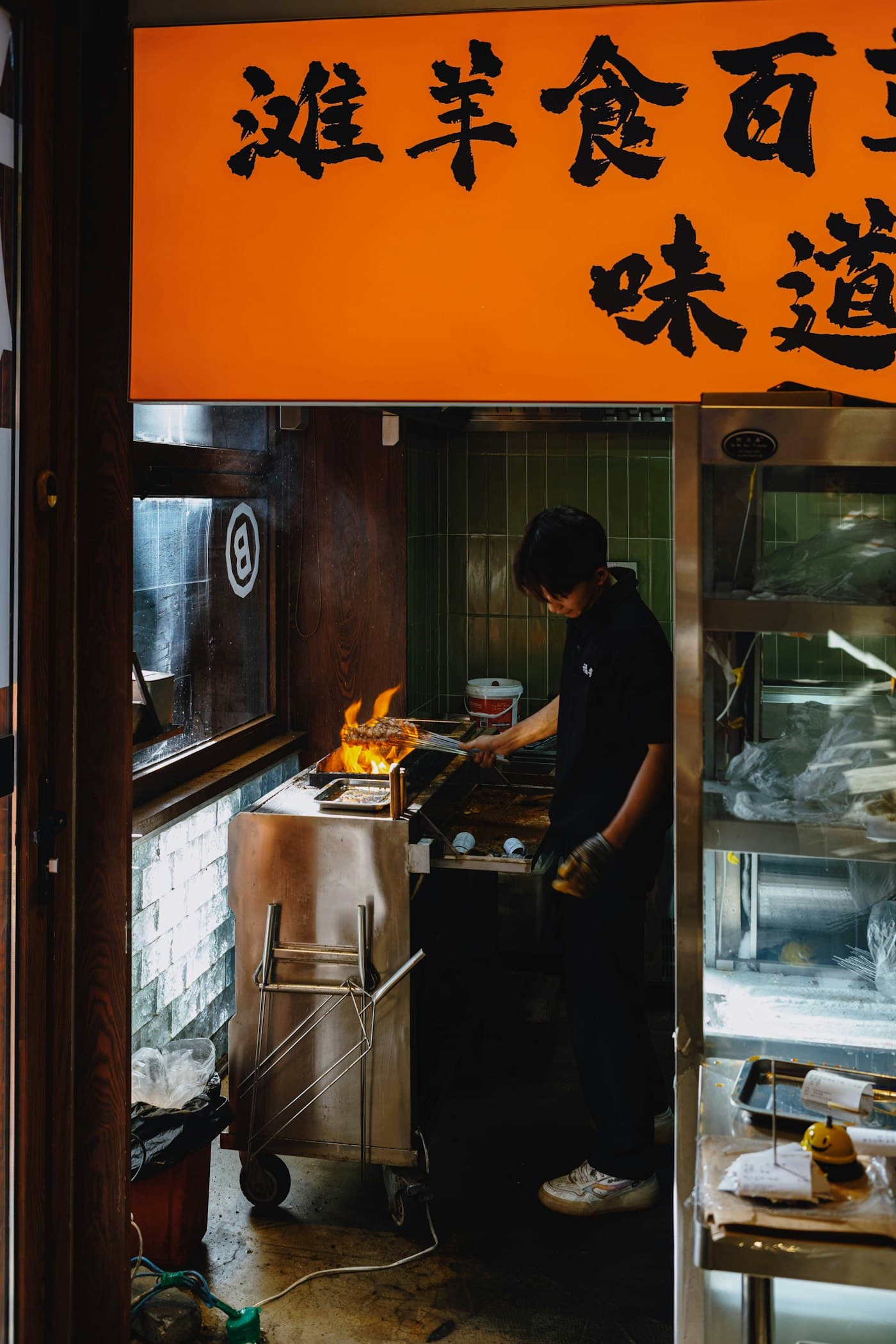 Chef flame-grilling at a street food counter