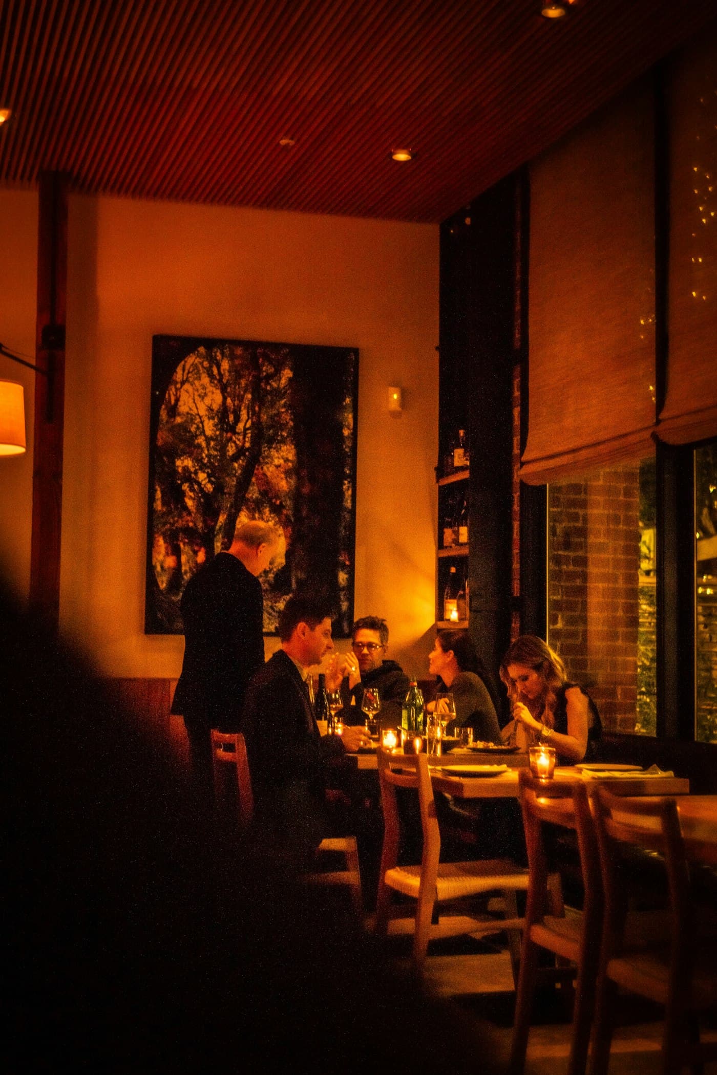 Warm, candlelit restaurant dining room at night